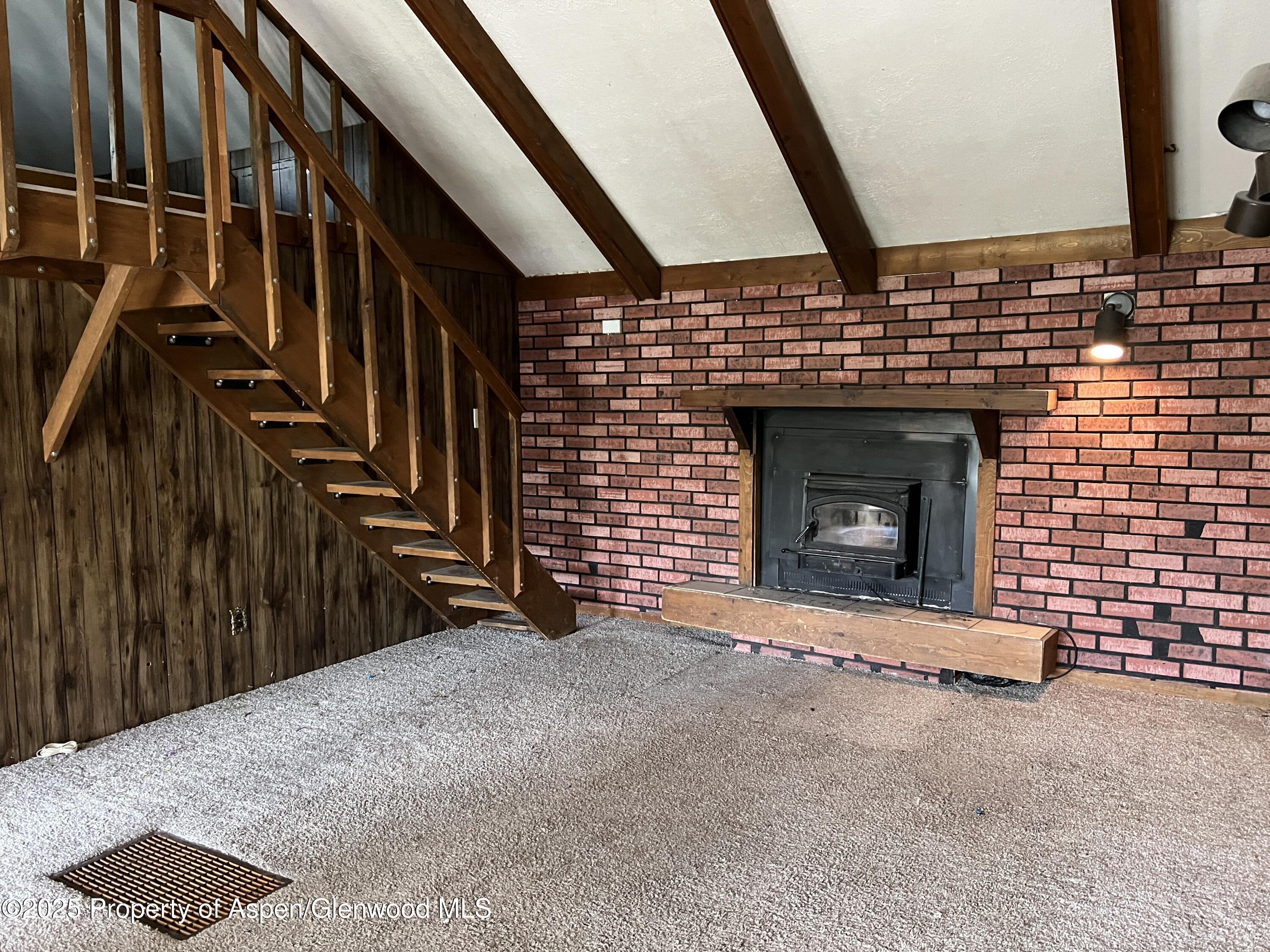 420 West 16th Street Rifle, CO 81650 - Photo 6 of 37 a view of an empty room with wooden floor and a fireplace