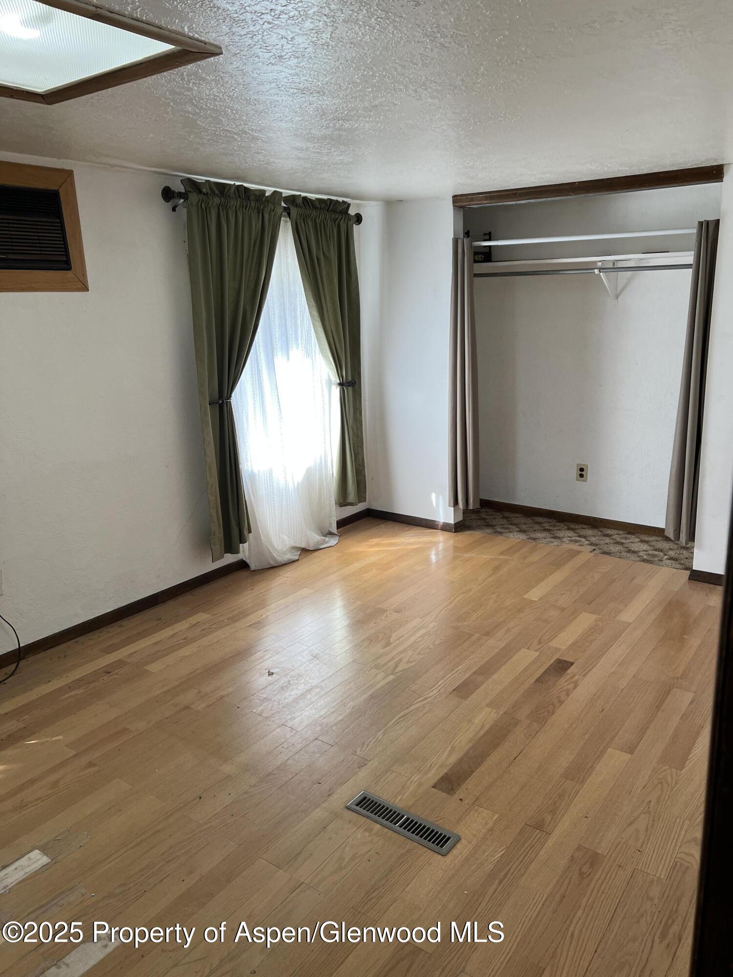 420 West 16th Street Rifle, CO 81650 - Photo 8 of 37 an empty room with wooden floor garage and window