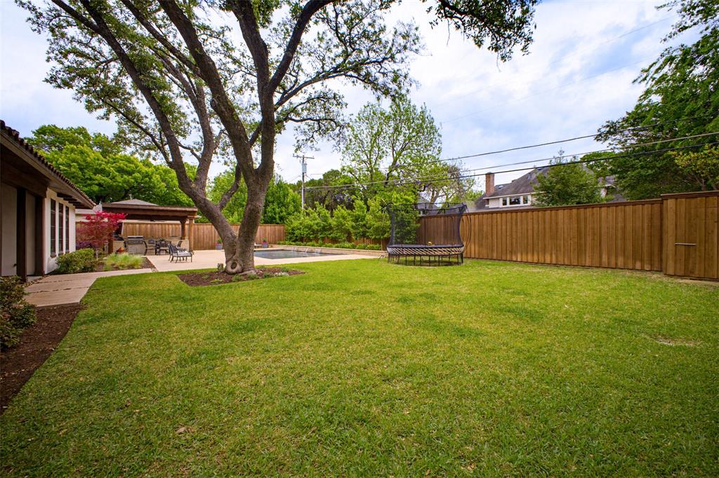 6622 Norway Road Dallas, TX 75230 - Photo 37 of 40 a view of a backyard with a garden and trees