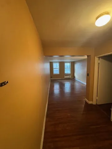 a view of empty room with wooden floor