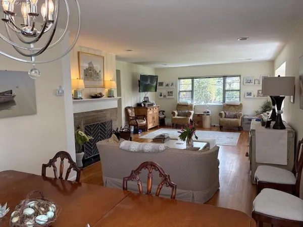 a living room with furniture a fireplace and a table with wooden floor