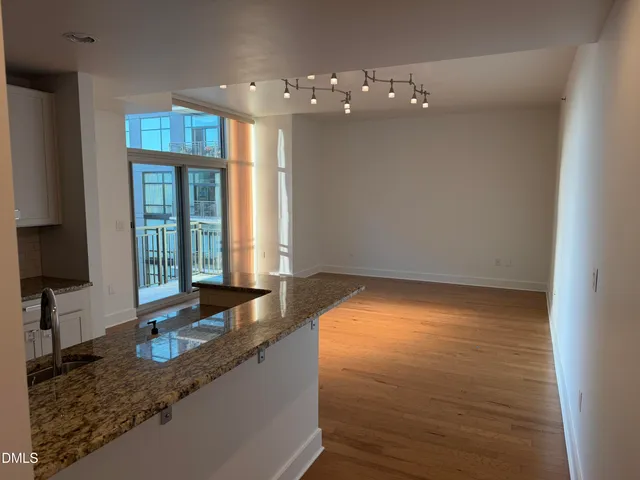 a kitchen with granite countertop a sink a stove and cabinets
