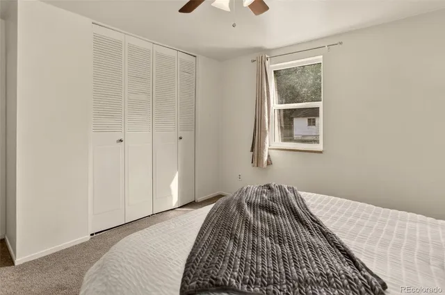 a bedroom with a bed and painting on the wall
