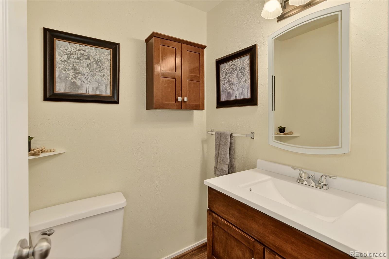 5846 South Pearl Street Centennial, CO 80121 - Photo 24 of 32 a bathroom with a granite countertop sink mirror vanity and toilet