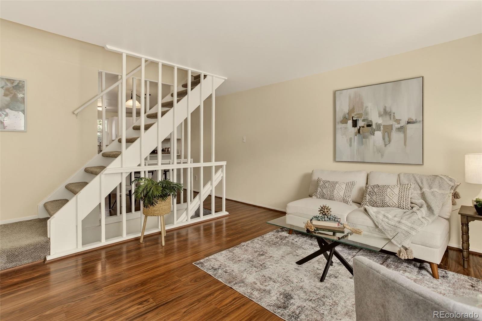 5846 South Pearl Street Centennial, CO 80121 - Photo 6 of 32 a living room with couches and a dining table with wooden floor