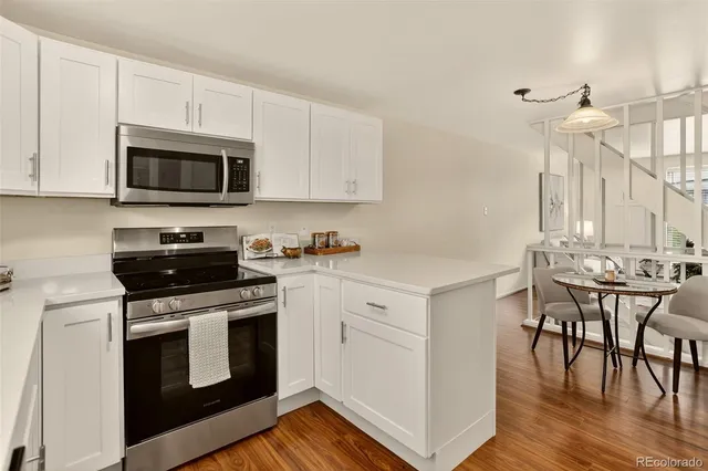 a kitchen with granite countertop a stove a sink and a microwave
