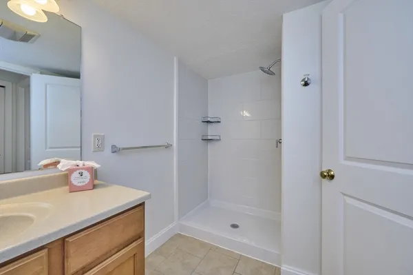 a bathroom with a shower sink vanity and toilet