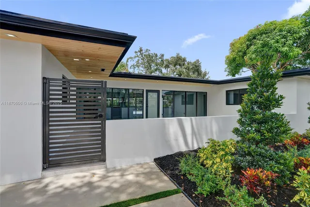 a view of a house with a large tree and a yard