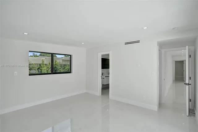 a view of an empty room with glass door and windows
