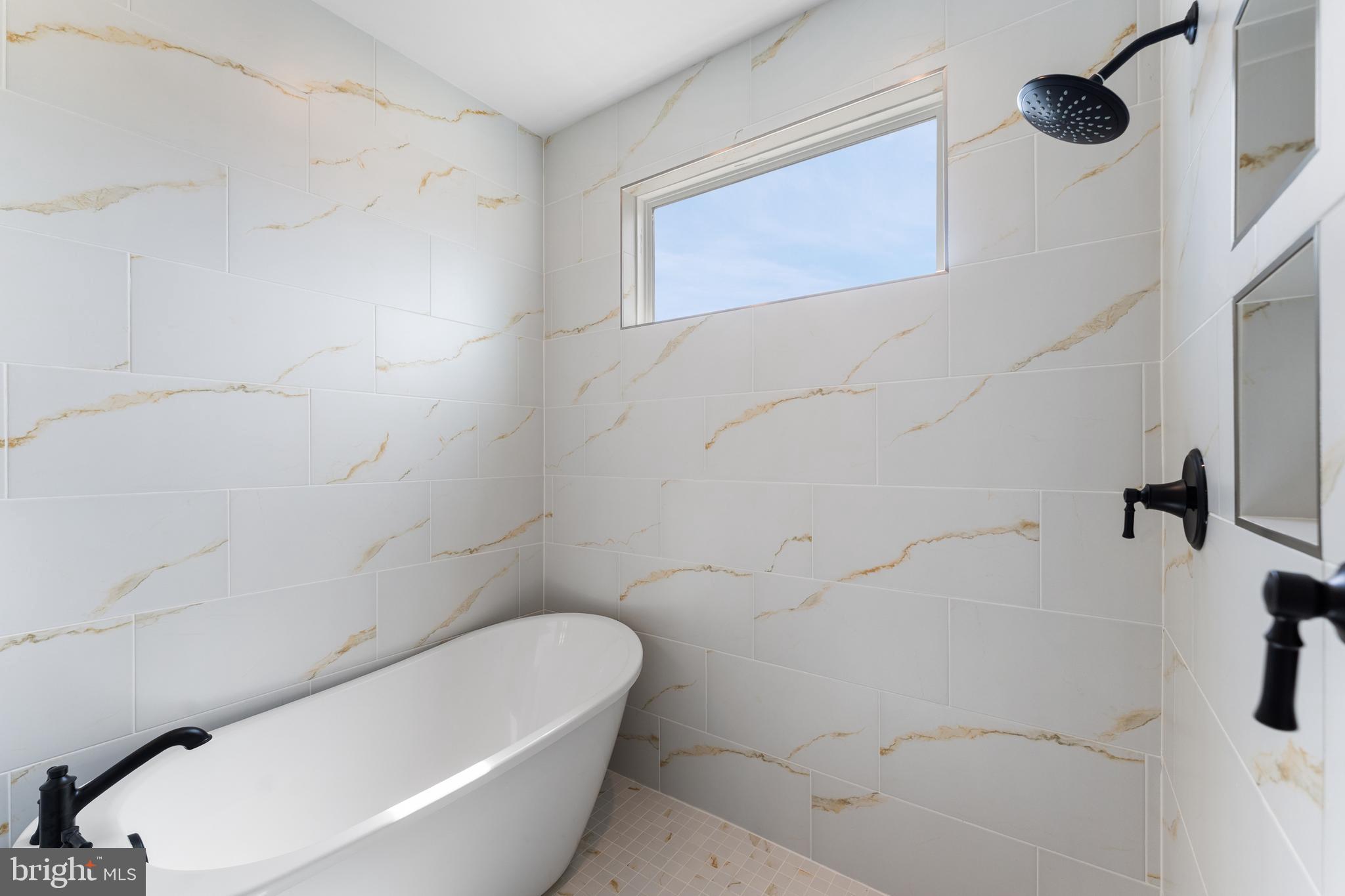 113 Summit Point Boulevard, Unit 19J Bowie, MD 20716 - Photo 18 of 38 a bathroom with a bathtub and shower