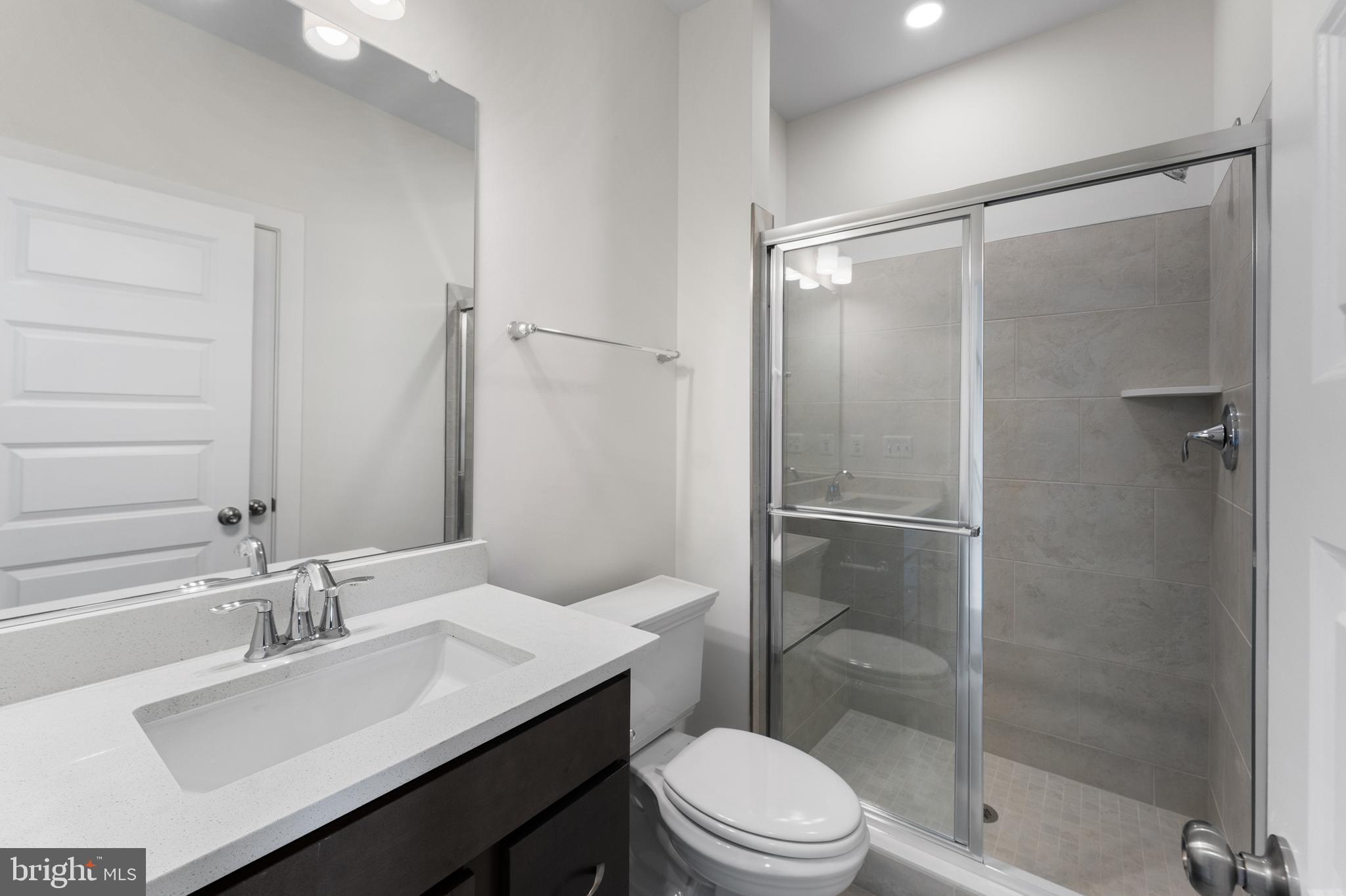 113 Summit Point Boulevard, Unit 19J Bowie, MD 20716 - Photo 22 of 38 a bathroom with a sink toilet and shower