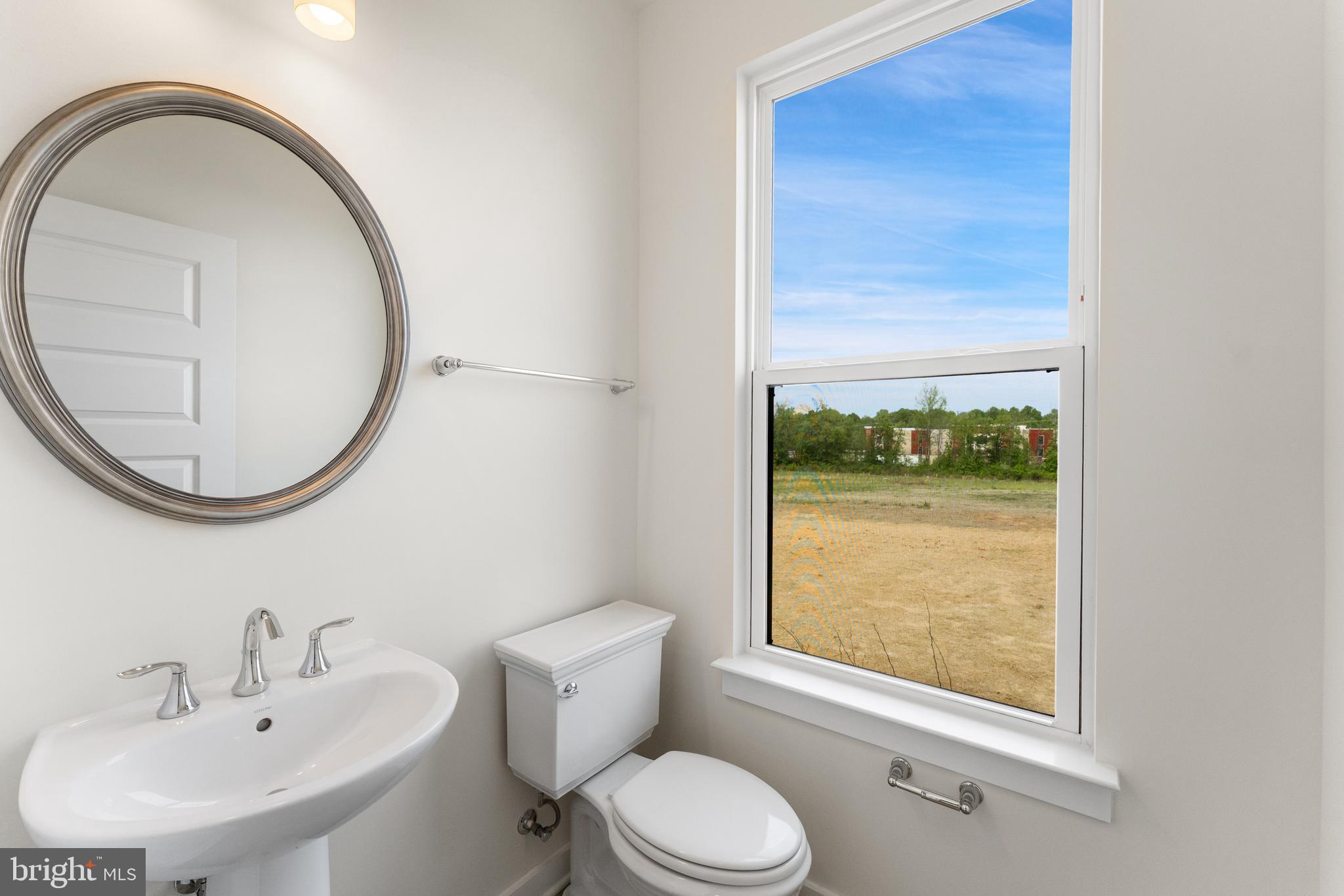 113 Summit Point Boulevard, Unit 19J Bowie, MD 20716 - Photo 26 of 38 a bathroom with a toilet a sink and a mirror