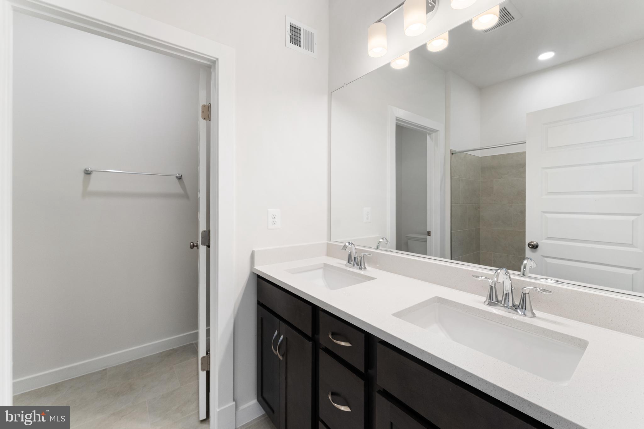 113 Summit Point Boulevard, Unit 19J Bowie, MD 20716 - Photo 29 of 38 a bathroom with a sink a vanity and a mirror