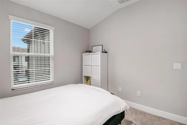 an aerial view of a house with a yard and a white building