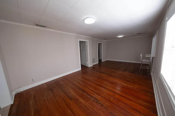 wooden floor in an empty room with a window
