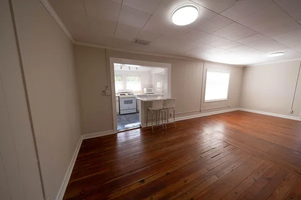 an empty room with wooden floor and windows