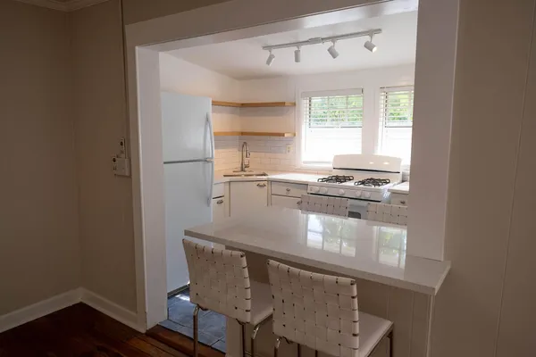 a kitchen with kitchen island a stove a sink and a window