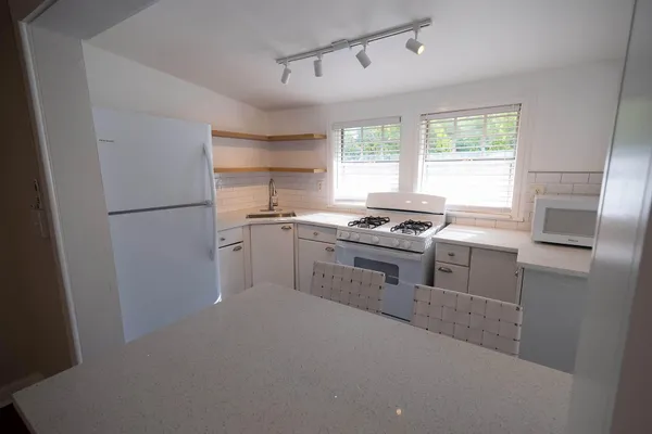 a kitchen with granite countertop a refrigerator stove top oven and sink