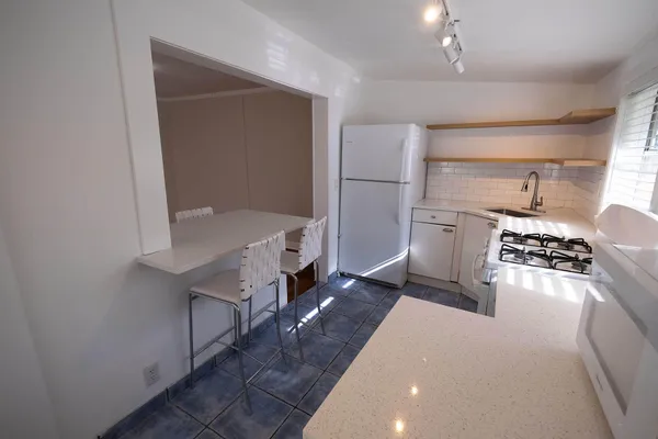 a kitchen with stainless steel appliances a refrigerator and a stove top oven