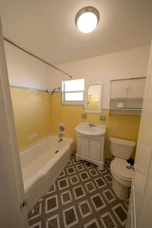 a bathroom with a sink a toilet a mirror and shower