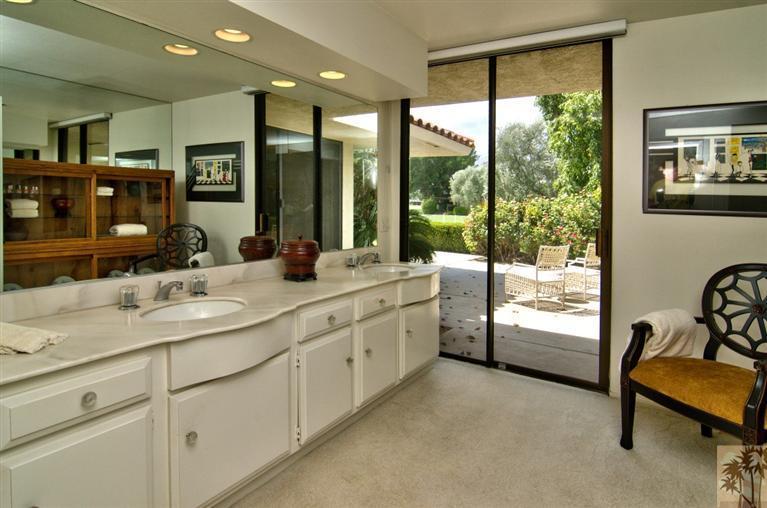 9 Seton Court Rancho Mirage, CA 92270 - Photo 19 of 42 a spacious bathroom with a double vanity sink large mirror and a large window