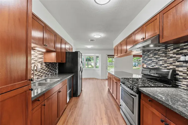 a kitchen with stainless steel appliances granite countertop a stove and a sink
