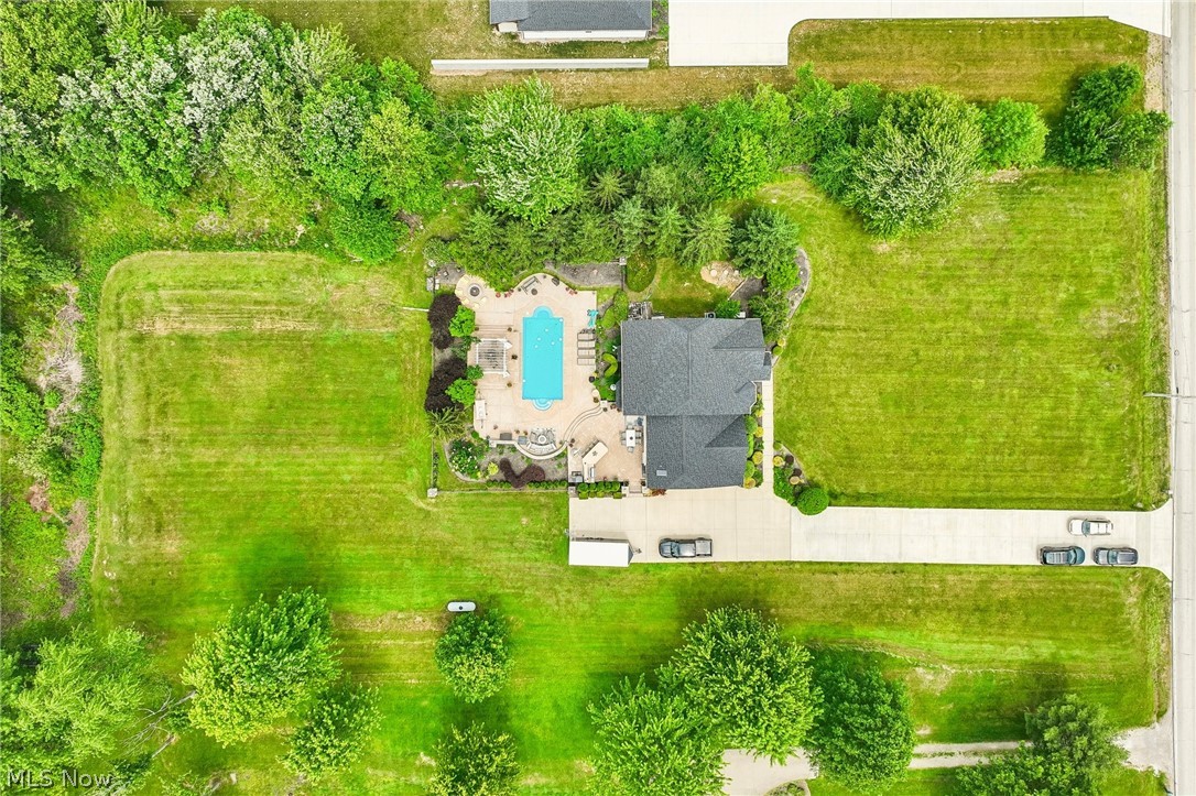 8874 Sharp Road Olmsted Falls, OH 44138 - Photo 40 of 42 Expansive property featuring a dark-roofed residence, a shaped swimming pool, surrounding patio space, extensive green lawn areas, and mature perimeter trees