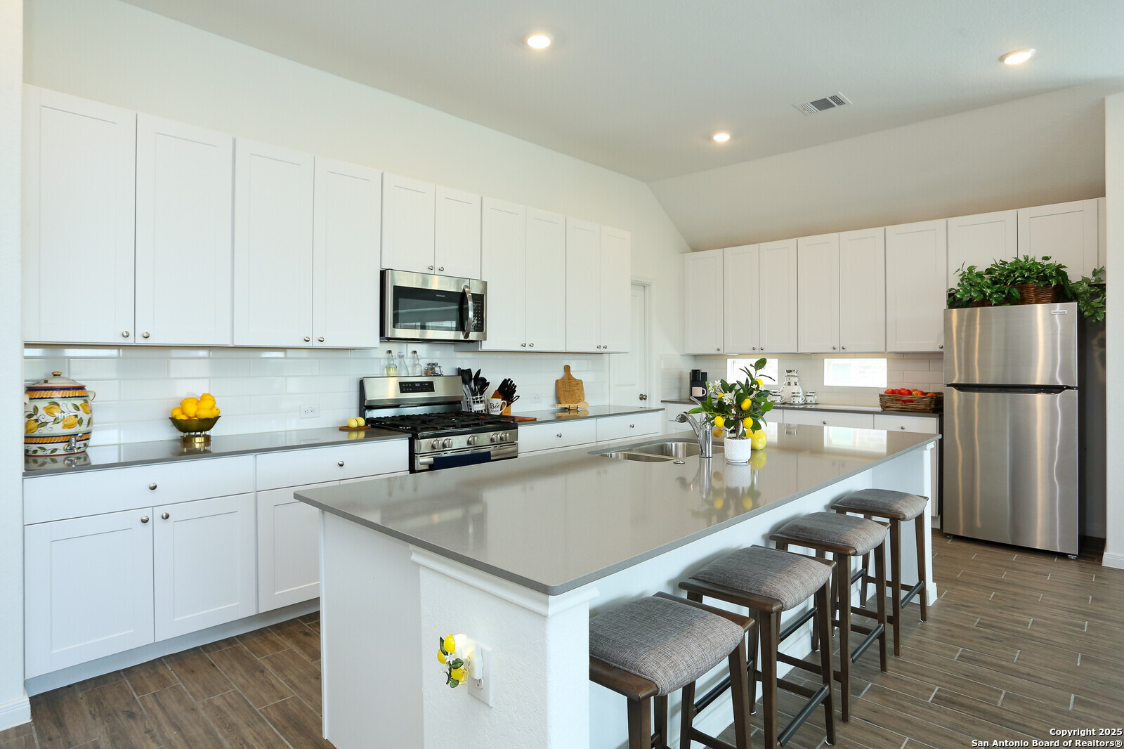 5798 Luciano Ridge Seguin, TX 78155 - Photo 9 of 36 a kitchen with a refrigerator a stove a sink a dining table and chairs