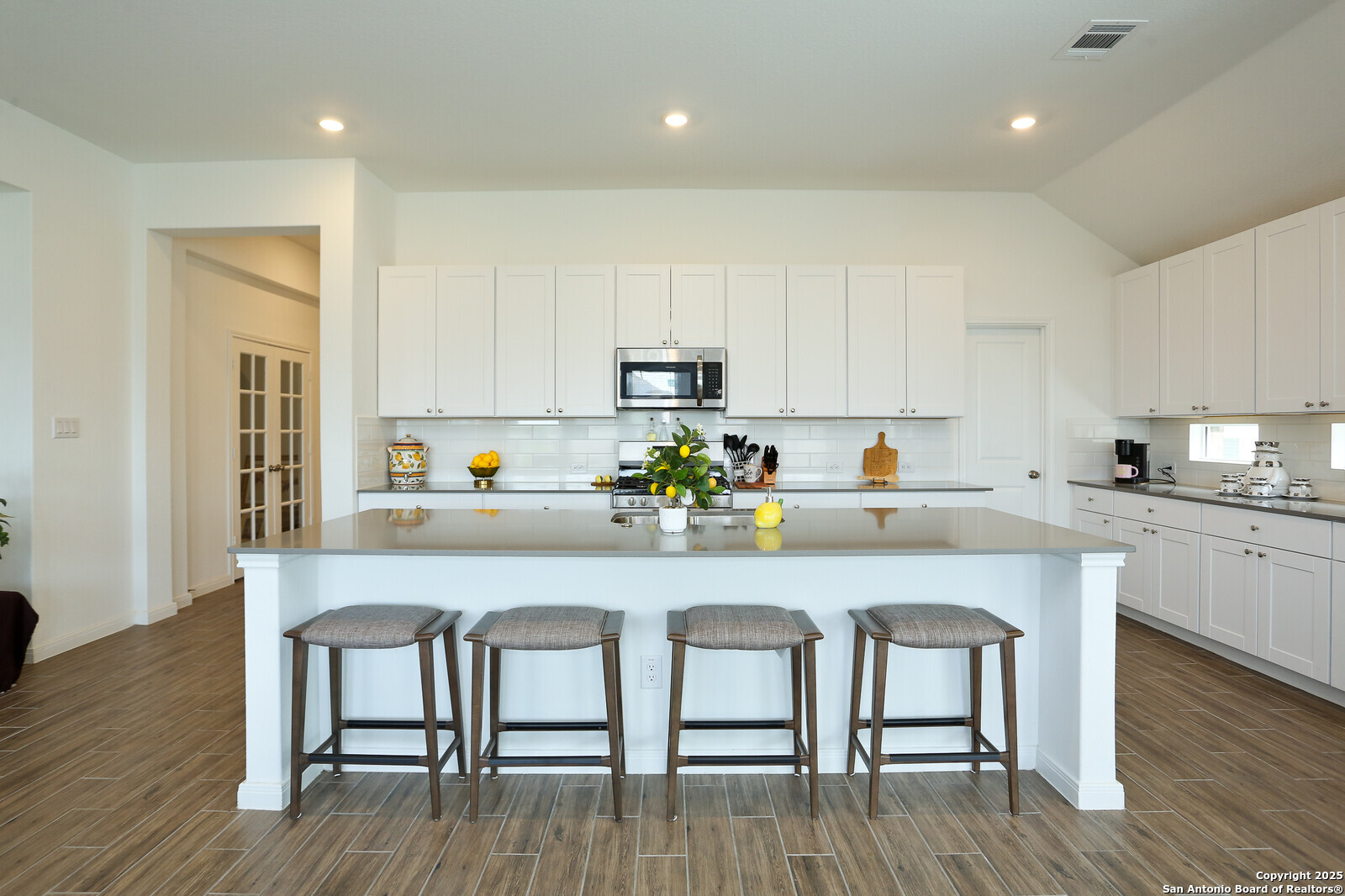 5798 Luciano Ridge Seguin, TX 78155 - Photo 10 of 36 a kitchen with granite countertop white cabinets and wooden floor