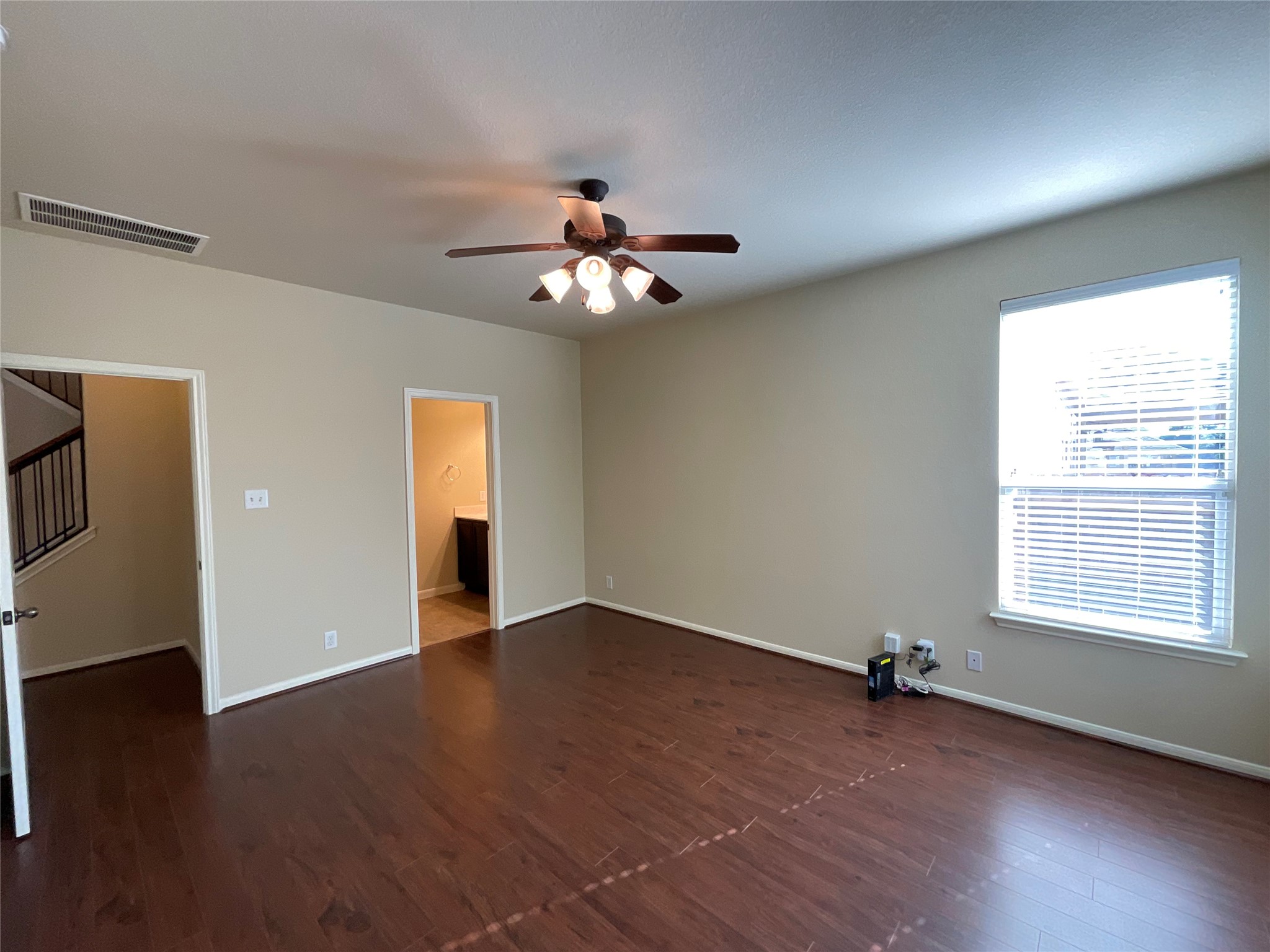 1911 Conn Creek Road Cedar Park, TX 78613 - Photo 22 of 39 an empty room with wooden floor chandelier fan and windows