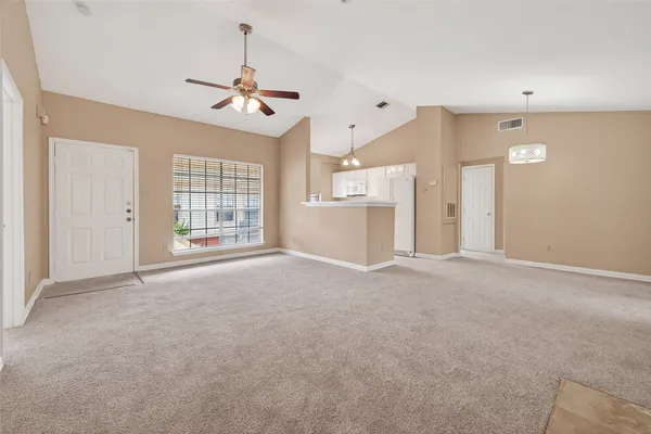a view of an empty room with a fireplace and a window
