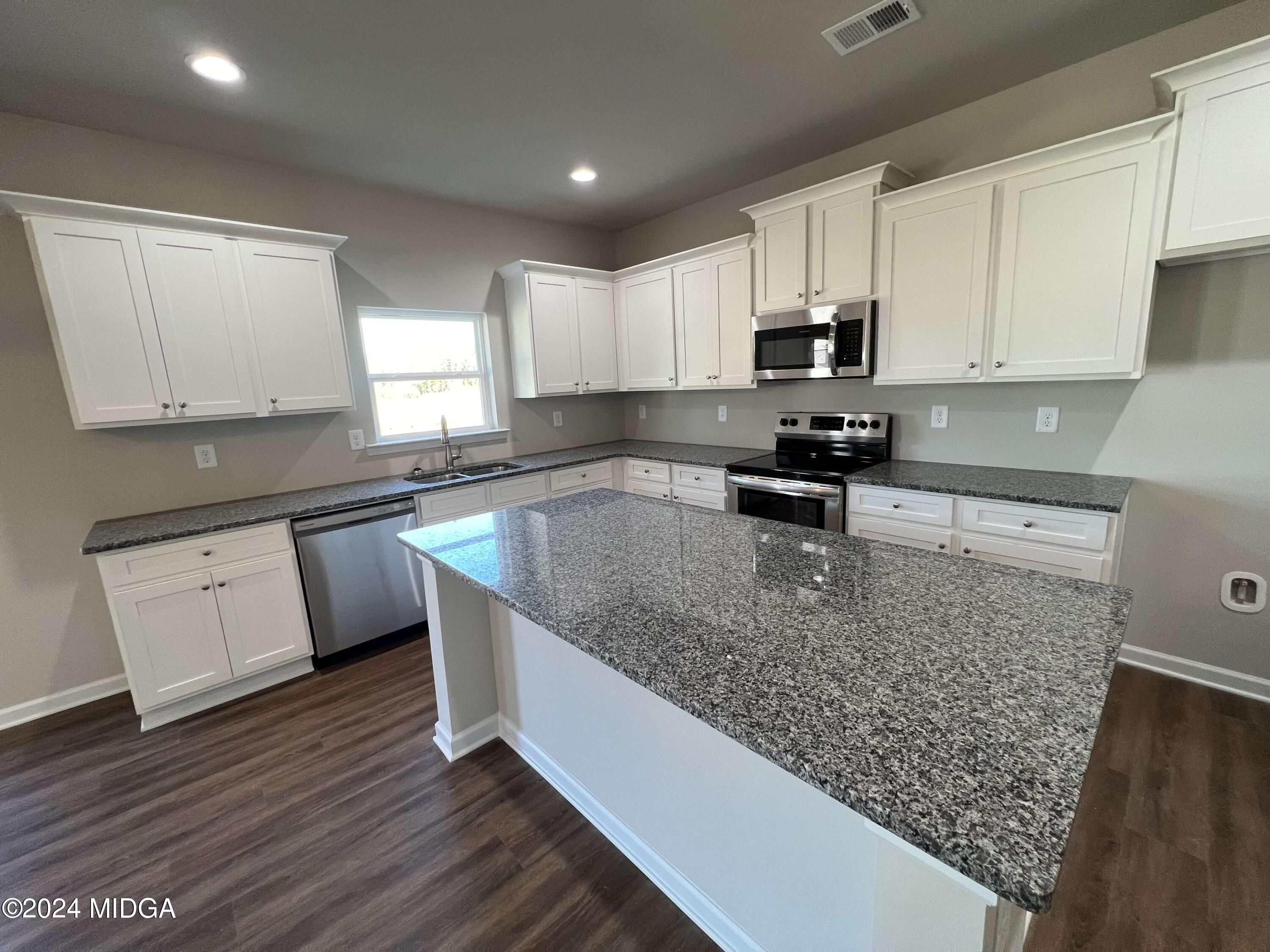 183 Sanders Road Macon, GA 31210 - Photo 8 of 44 a kitchen with stainless steel appliances granite countertop a sink a stove top oven a counter space and cabinets