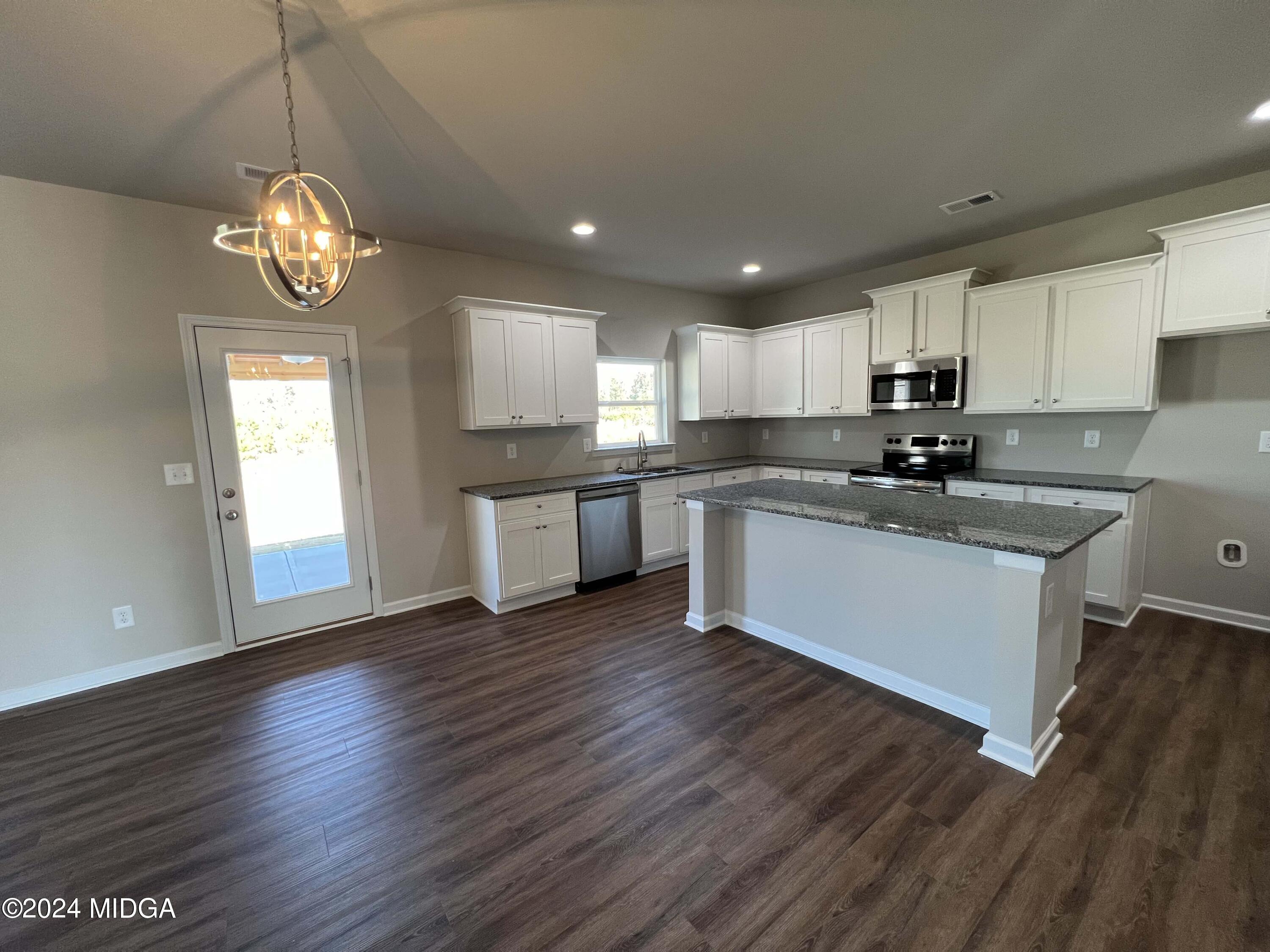 183 Sanders Road Macon, GA 31210 - Photo 10 of 44 a kitchen with cabinets wooden floor and stainless steel appliances