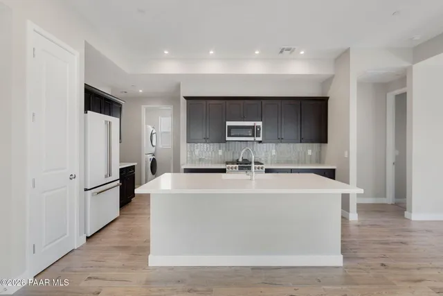 a large white kitchen with stainless steel appliances