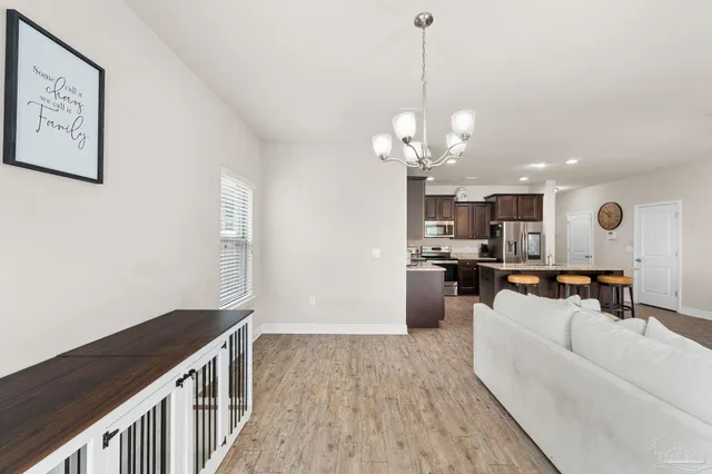 a living room with furniture kitchen view and a chandelier