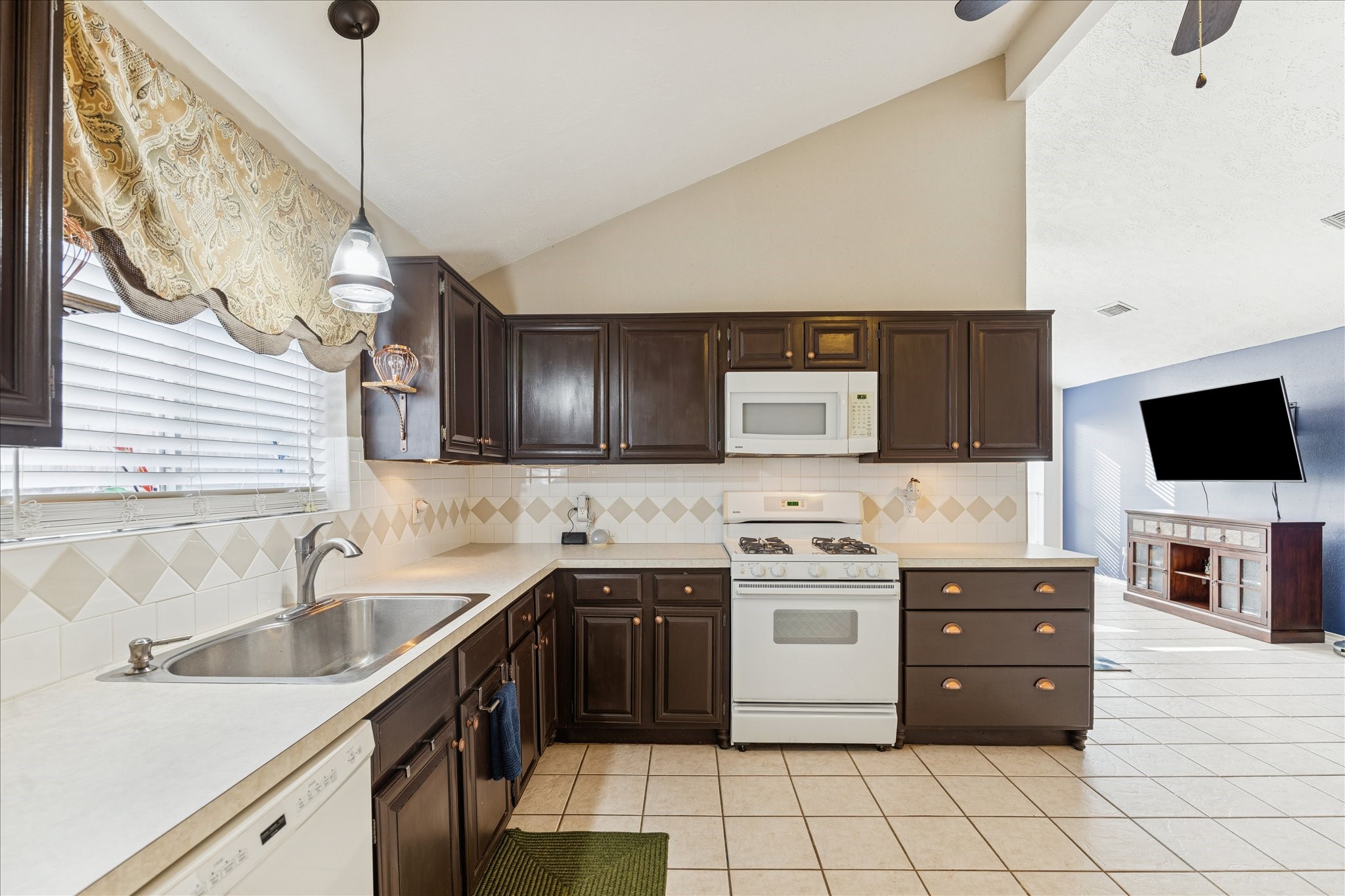 24919 Bovington Drive Spring, TX 77389 - Photo 3 of 21 The kitchen opens up to the living room and also has vaulted ceilings.