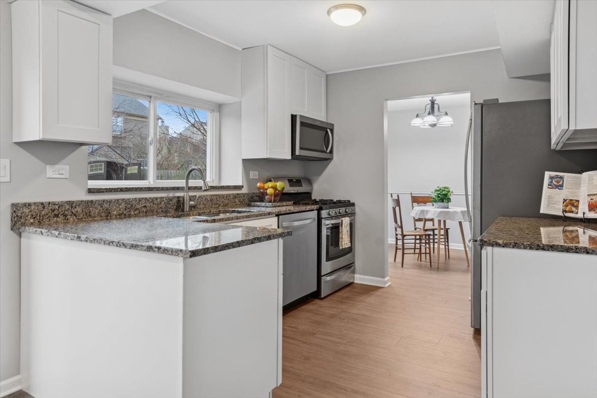 3131 Portland Court Aurora, IL 60504 - Photo 6 of 20 a kitchen with stainless steel appliances granite countertop a stove top oven a sink a counter space and cabinets