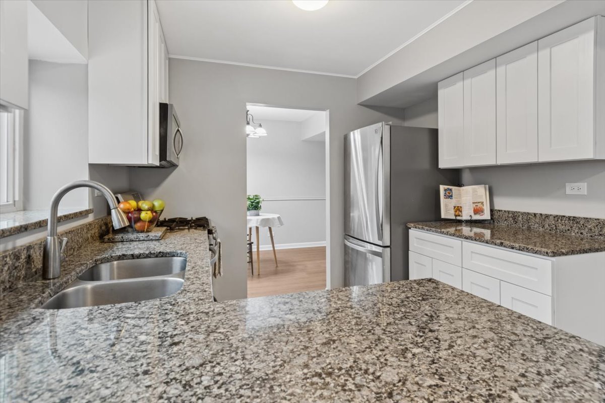 3131 Portland Court Aurora, IL 60504 - Photo 7 of 20 a kitchen with stainless steel appliances kitchen island granite countertop a refrigerator and a sink