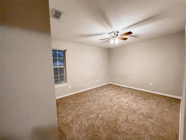 an empty room with windows and fan