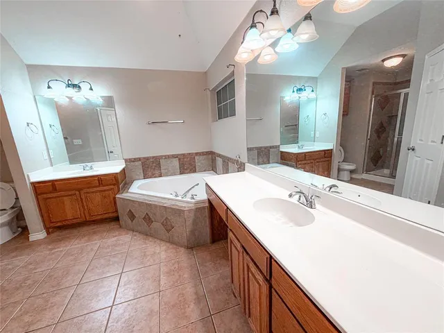 a spacious bathroom with a double vanity sink mirror and bathtub