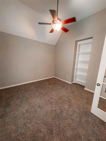 an empty room with closet and fan