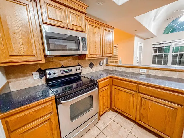 a kitchen with granite countertop cabinets stainless steel appliances and a sink