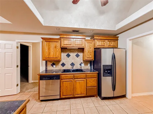 a kitchen with stainless steel appliances granite countertop a refrigerator and a stove