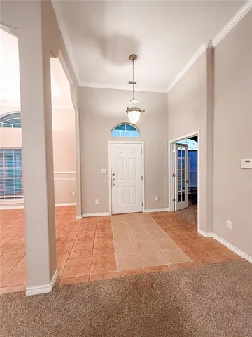 a view of an empty room with wooden floor and windows