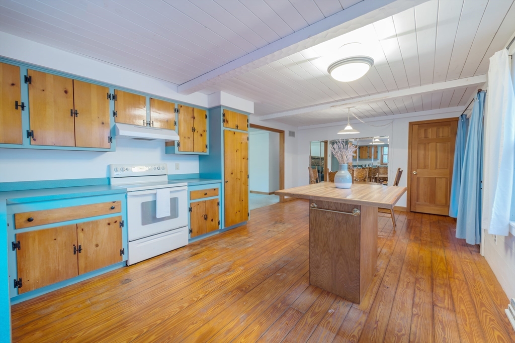 4 Coombs Road Rochester, MA 02770 - Photo 8 of 27 a kitchen with wooden floors and wooden cabinets