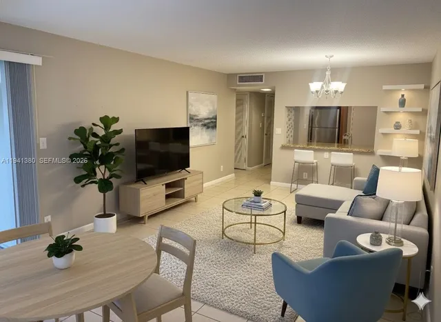 a living room with furniture a flat screen tv and a potted plant