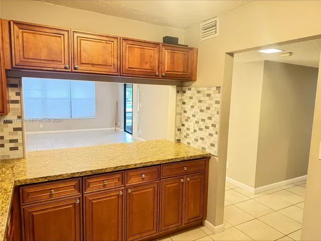 a kitchen with granite countertop a sink and a shower