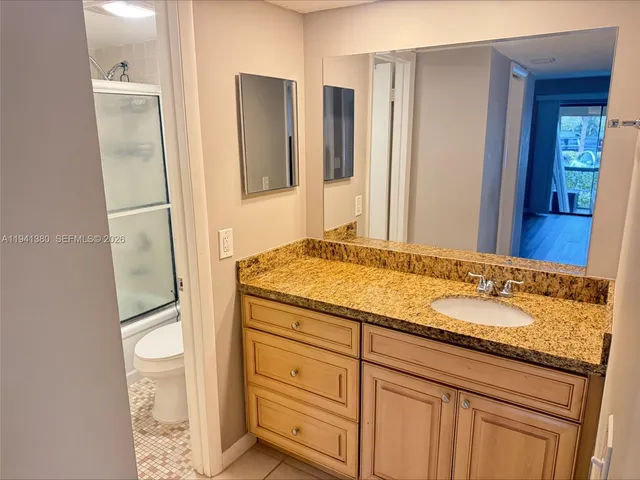 a bathroom with a granite countertop sink and a mirror