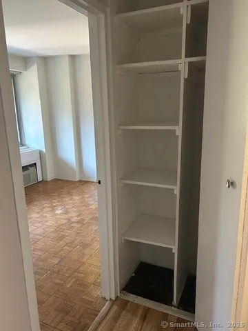 a view of walk in closet with wooden floor