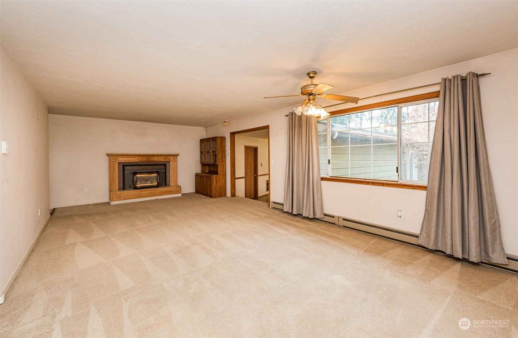 970 River Road Sequim, WA 98382 - Photo 3 of 40 an empty room with fireplace and windows